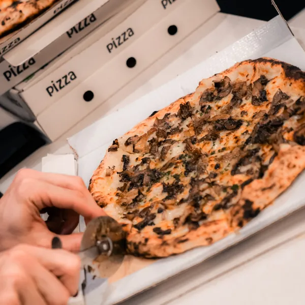 Mushroom pizza being sliced at a Velvet members night